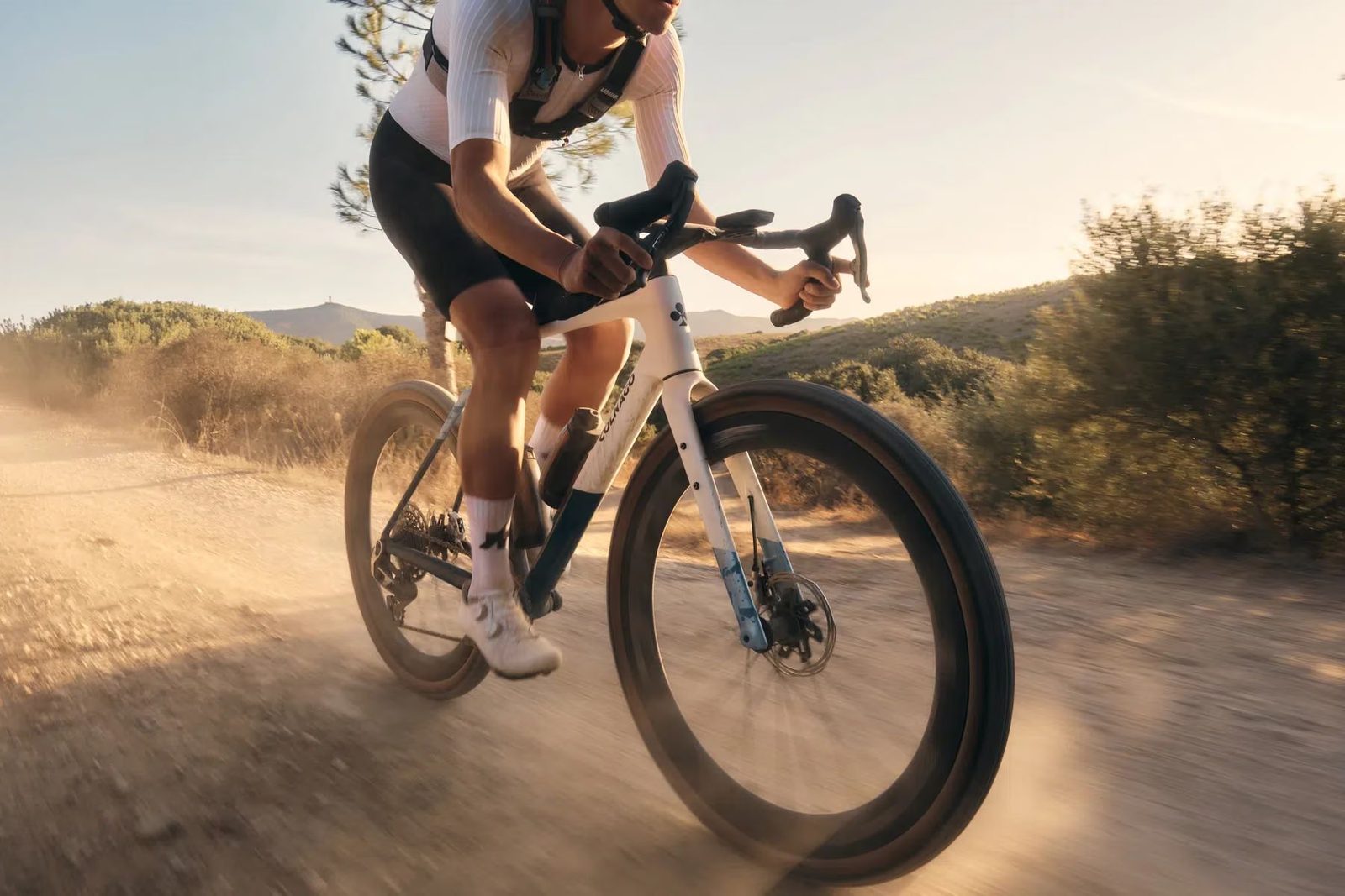 Colnago gravel bike rider dusty dirt road sunset